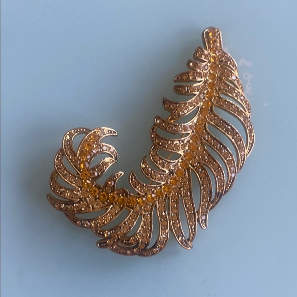 Gold brooch feather with golden rhinestone